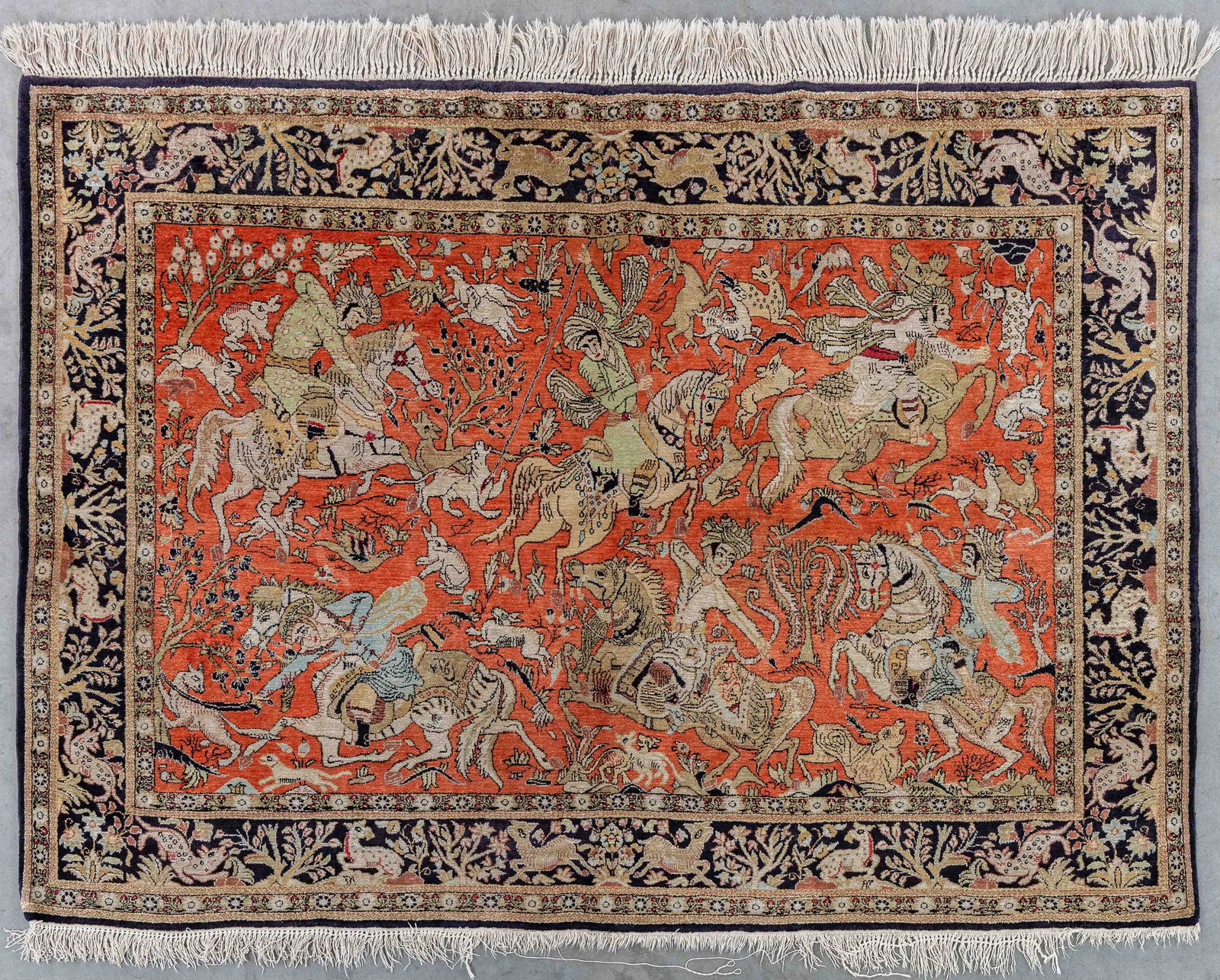 An Oriental hand-made carpet, figurative decor with hunting scene, Ghoum, Iran (110 x 156 cm).: An Oriental hand-made carpet, figurative decor with hunting scene, Ghoum, Iran (110 x 156 cm). Dimensions: (W:110 x L:156 cm) The absence of a condition report does not imply a perfect item. Please se