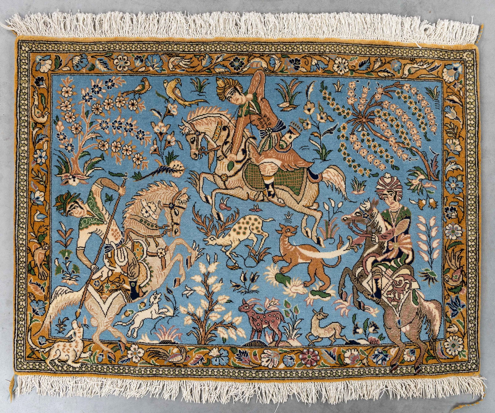 An Oriental hand-made carpet, figurative decor with hunting scene, Ghoum, Iran (78 x 107 cm).: An Oriental hand-made carpet, figurative decor with hunting scene, Ghoum, Iran (78 x 107 cm). Dimensions: (W:107 x H:78 cm) The absence of a condition report does not imply a perfect item. Please send