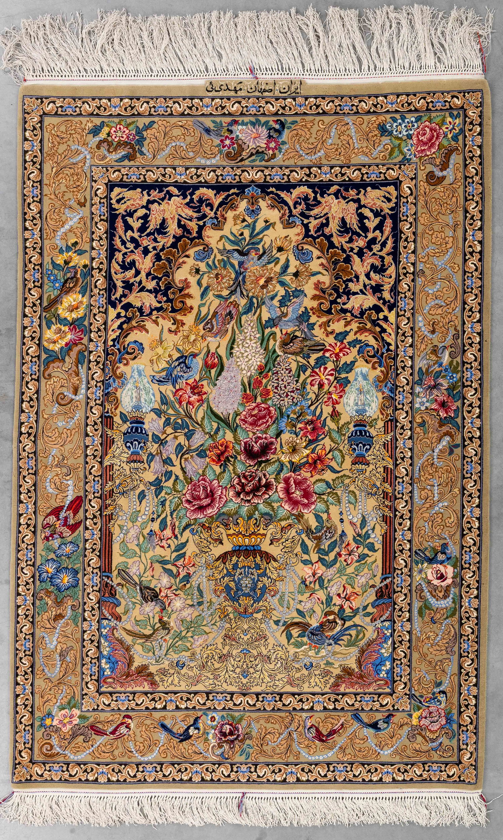 An oriental hand-made carpet, Isfahan, Iran (165 x 111 cm).: An oriental hand-made carpet, Isfahan, Iran (165 x 111 cm). With figurative decoration.Signed. Dimensions: (W:111 x H:165 cm) The absence of a condition report does not imply a perfect item. Please se