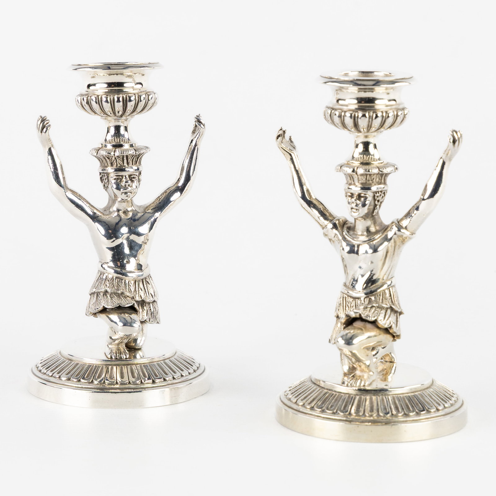 A pair of table candlesticks featuring 'Blackamoor' figures, silver-plated metal. 20th C.: A pair of table candlesticks featuring 'Blackamoor' figures, silver-plated metal. 20th century. Not signed. Silver-plated metal. Dimensions: (W:8 x H:14,5 cm) The absence of a condition report does no