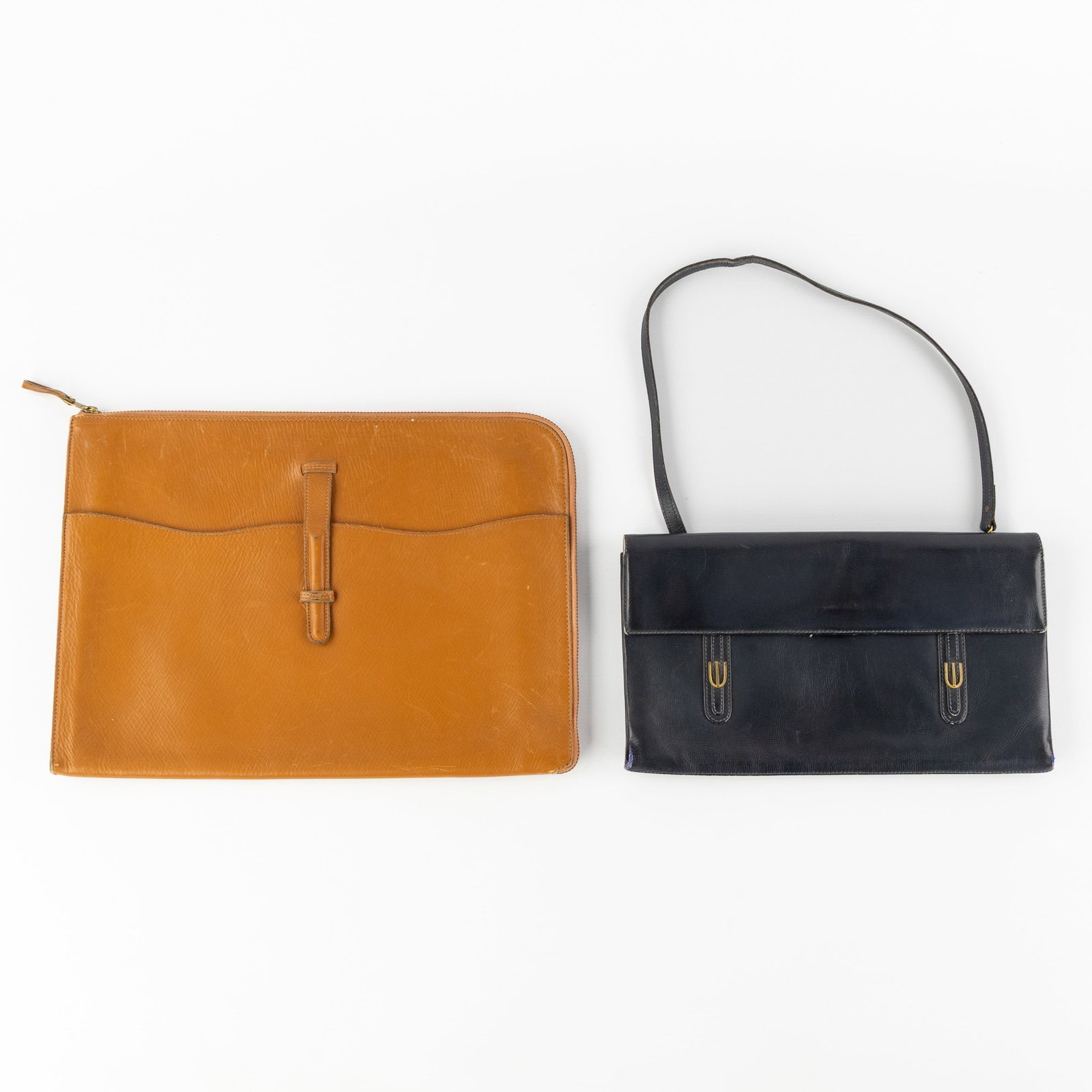 Delvaux, a vintage envelope or clutch and a cover bag, cognac and dark blue leather.: Delvaux, a vintage envelope or clutch and a cover bag, cognac and dark blue leather. Envelope or clutch, cognac leather.Marked Delvaux.(H: 30cm x W: 41cm). Cover bag, dark blue leather.Marked Delvaux.