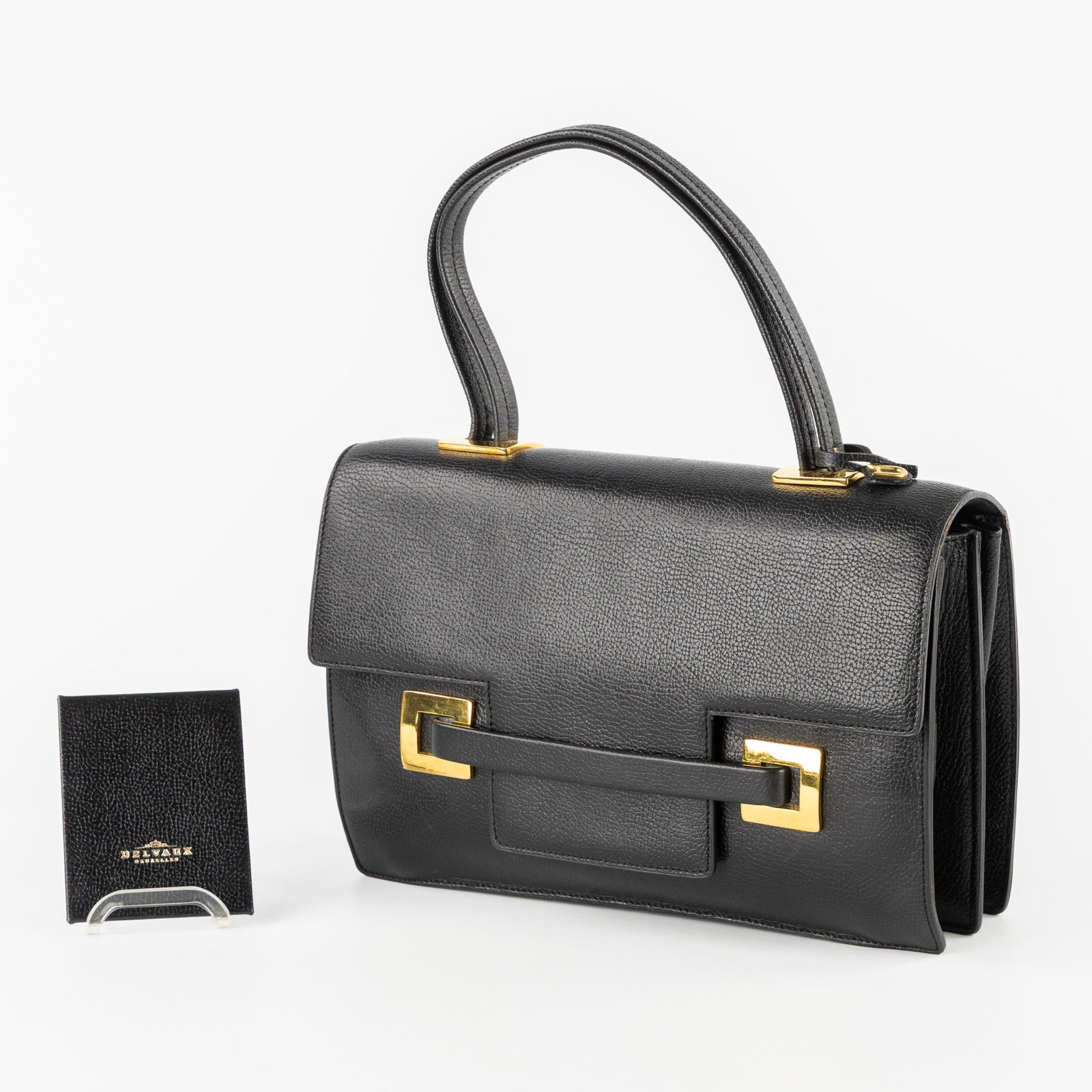 Delvaux, model Xylophone/Beau Temps, a handbag in black leather. : Delvaux, model Xylophone/Beau Temps, a handbag in black leather. With the matching mirror and storage pouch made of fabric. There is a document with the handbag declaring it as a model “Beau Tem