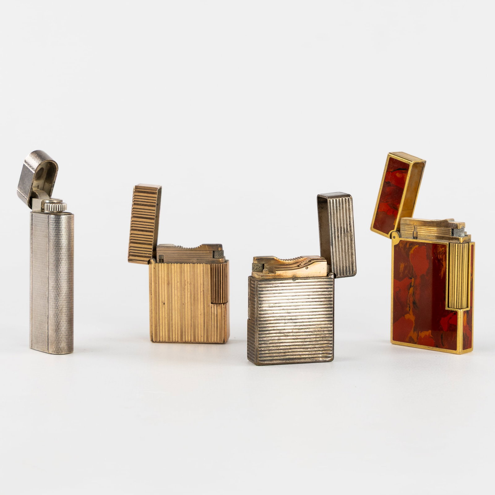 S.T. Dupont and Cartier, a Collection of Three Lighters, Gold-Plated and Silver-Plated. (1 of 6)