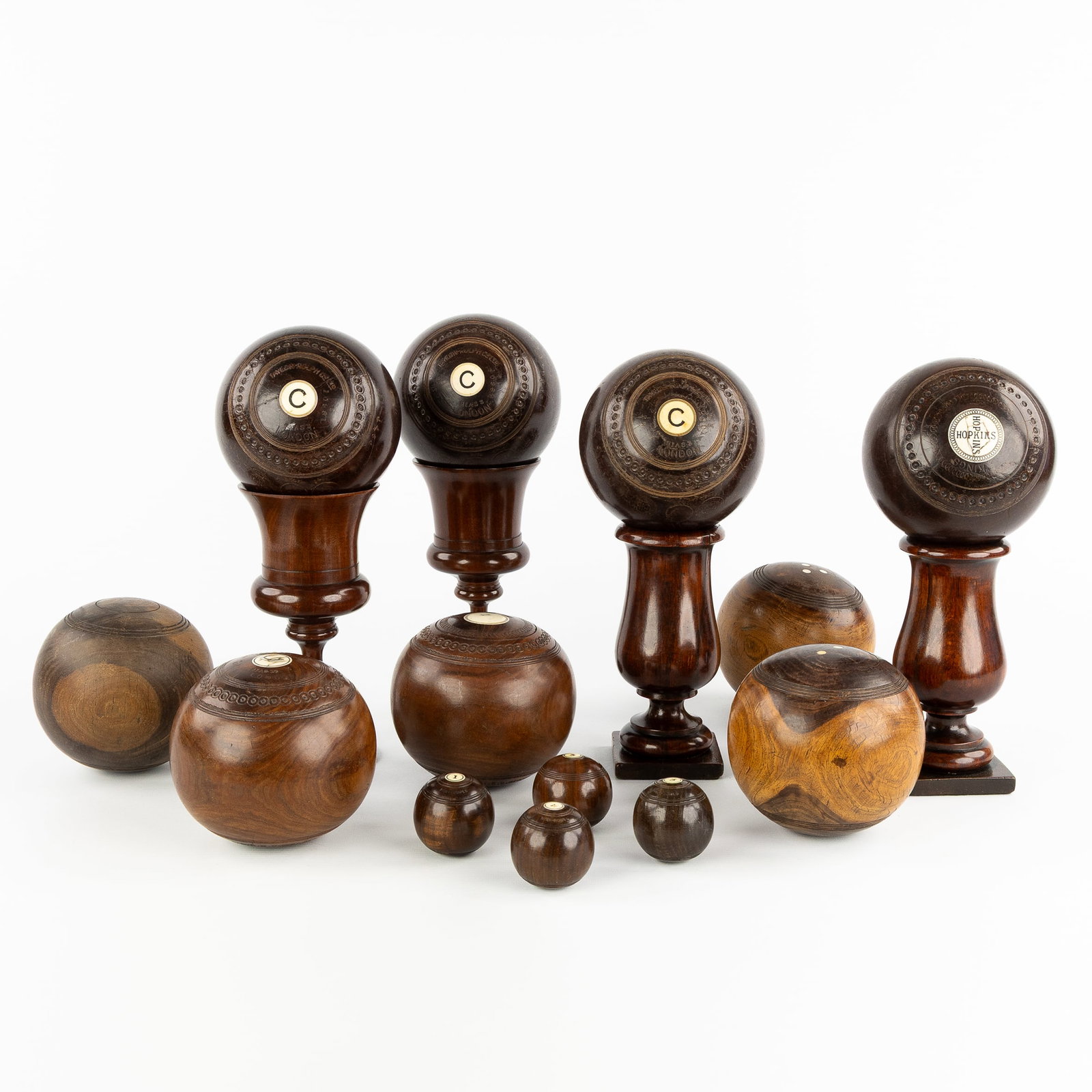 Taylor-Rolph Co., Jacques & Son, a collection of 13 lignum vitae 'Lawn Balls' and 4 stands/cups,: Taylor-Rolph Co., Jacques & Son, a collection of 13 lignum vitae 'Lawn Balls' and 4 stands/cups, England, early 20th century.
