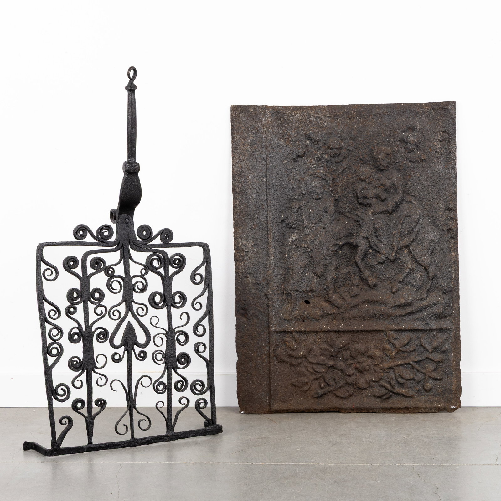 An Antique cast iron hearth plate 'Flight into Egypt' and wrought iron trivet, 17th/19th C.: An Antique cast iron hearth plate 'Flight into Egypt' and wrought iron trivet, 17th/19th century. Cast iron hearth plate.With a depiction of the Biblical scene 'Flight into Egypt'.17th/18th century.