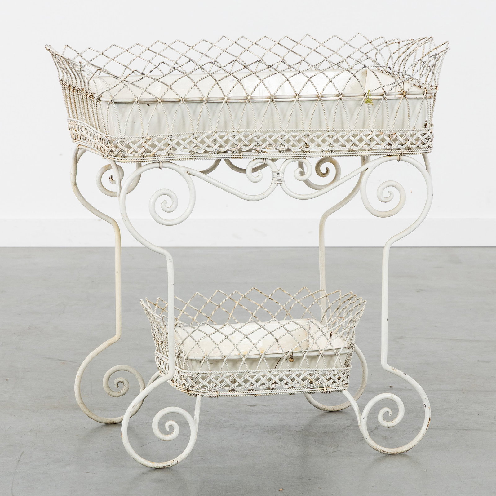 A White patinated wrought iron jardinière or plant stand, France, circa 1900.: A White patinated wrought iron jardinière or plant stand, France, circa 1900. White patinated wrought iron and braided wire.Two-tier jardinière or plant stand, with two removable trays.