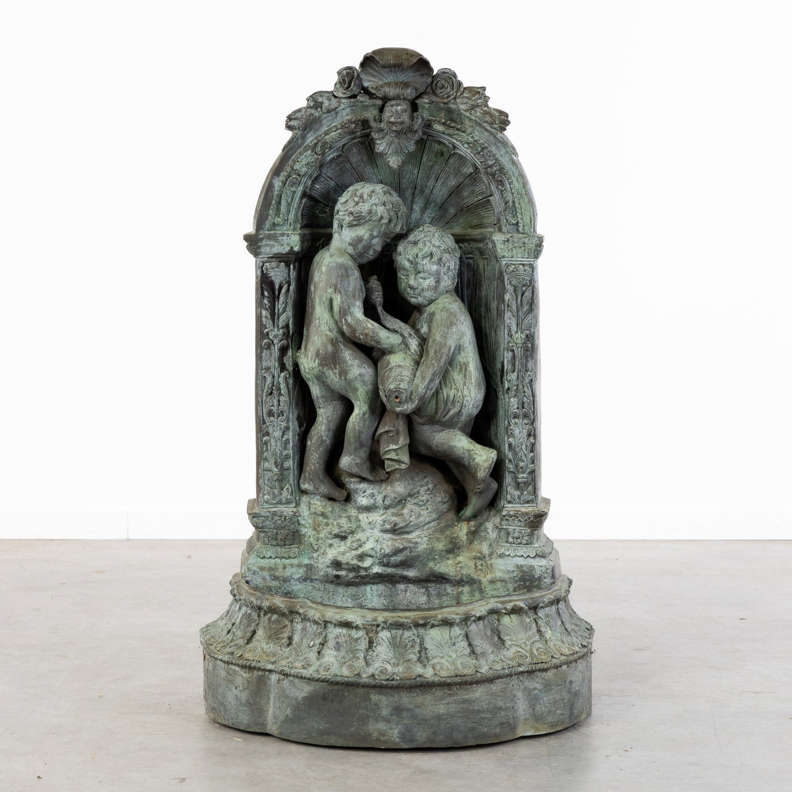 A Bronze wall fountain with Putti or Amours.: A Bronze wall fountain with Putti or Amours. Bronze.Wall fountain or garden fountain, decorated with two putti or amours with a water jug. (72 x 118 x 56 cm)