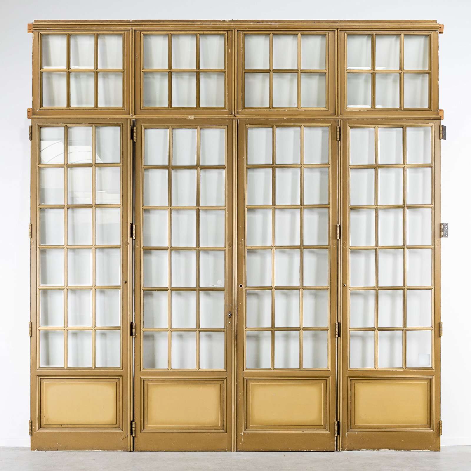 A Large four-panel orangery door with transom, patinated wood and glass, circa 1900.: A Large four-panel orangery door with transom, patinated wood and glass, circa 1900. Patinated wood.Orangery door, with four hinged doors featuring a grid of small bevelled glass panes (rods) and an i