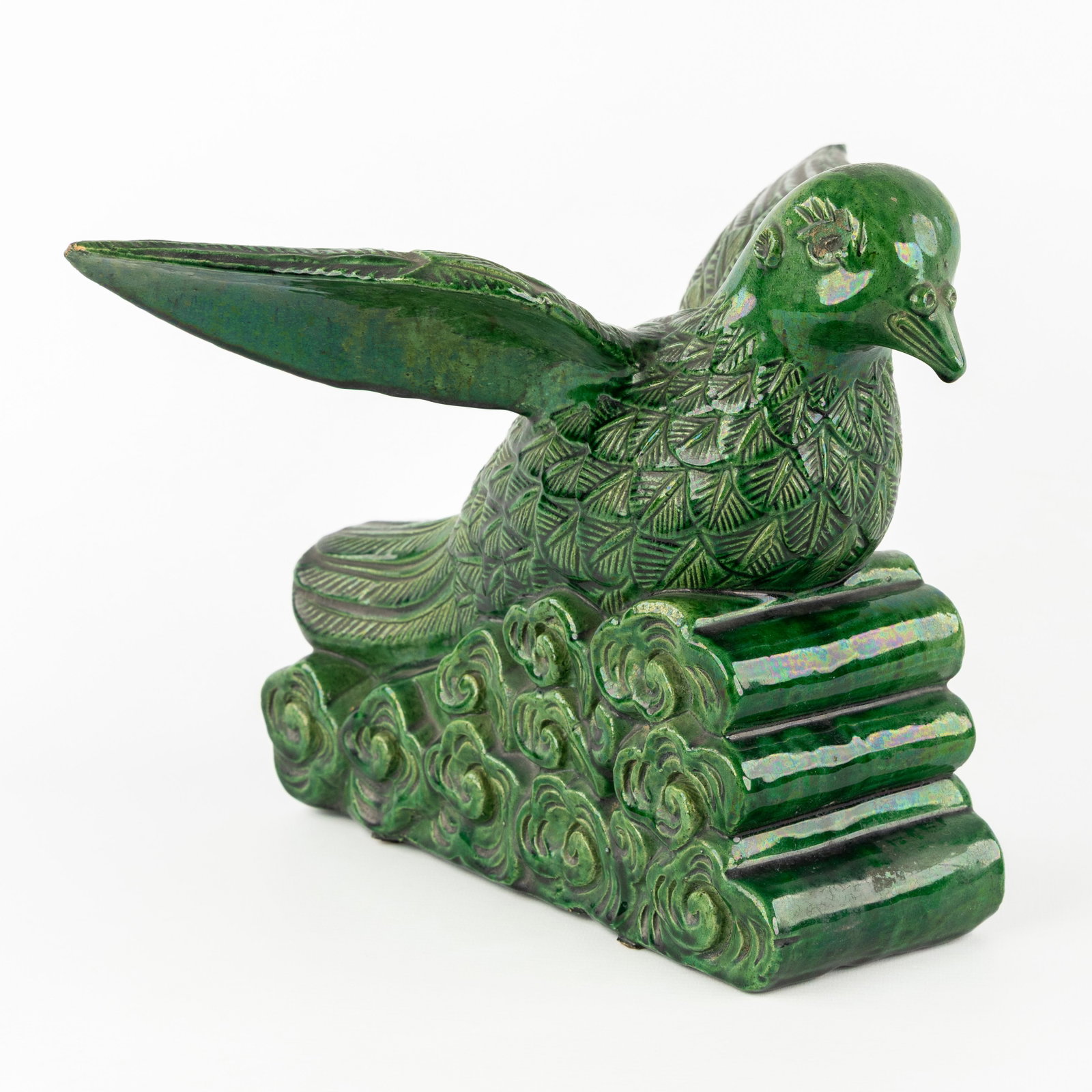 A sculpture of a bird, glazed terracotta.: A sculpture of a bird, glazed terracotta. Green glazed terracotta.sculpture in the shape of a bird or dove floating on stylized clouds. (35 x 24.5 x 27 cm)