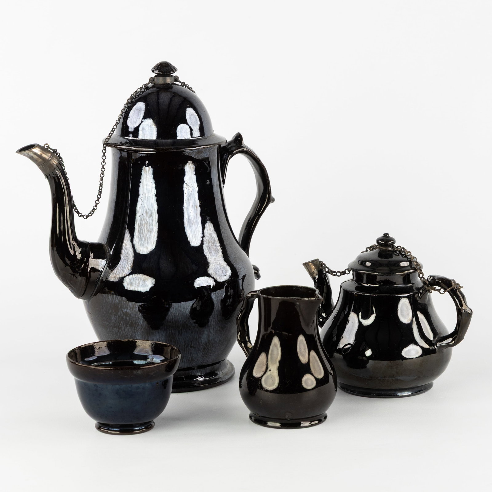 A Black glazed coffee and tea set, glazed earthenware with silver mount, Namur, 18th/19th C.: A Black glazed coffee and tea set, glazed earthenware with silver mount, Namur, 18th/19th century. Glazed earthenware.Coffee and tea set with coffee pot, teapot, milk jug, and sugar bowl.Coffee pot