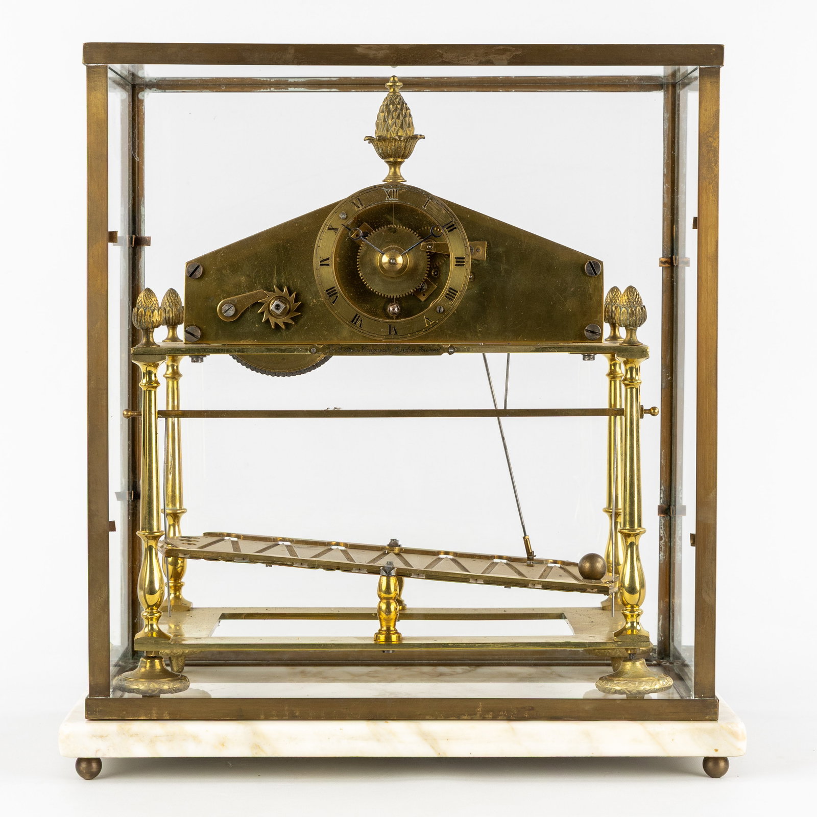 A ‘Congrieve’ or ‘Rolling Ball’ clock, made of brass and marble under a: A ‘Congrieve’ or ‘Rolling Ball’ clock, made of brass and marble under a glass case. 20th century. A ‘Congrieve’ or ‘Rolling Ball’ clock. On t