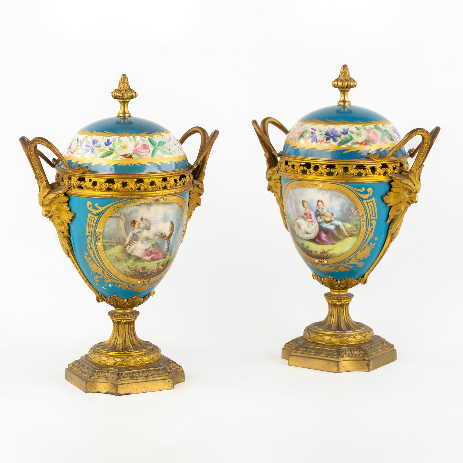 A Pair of Sèvres covered vases, 'Bleu Céleste' porcelain, gilded bronze and hand-painted: A Pair of Sèvres covered vases, 'Bleu Céleste' porcelain, gilded bronze and hand-painted decorations, circa 1900. Porcelain, Bleu Céleste with gilded finish.Hand-painted figurative scen