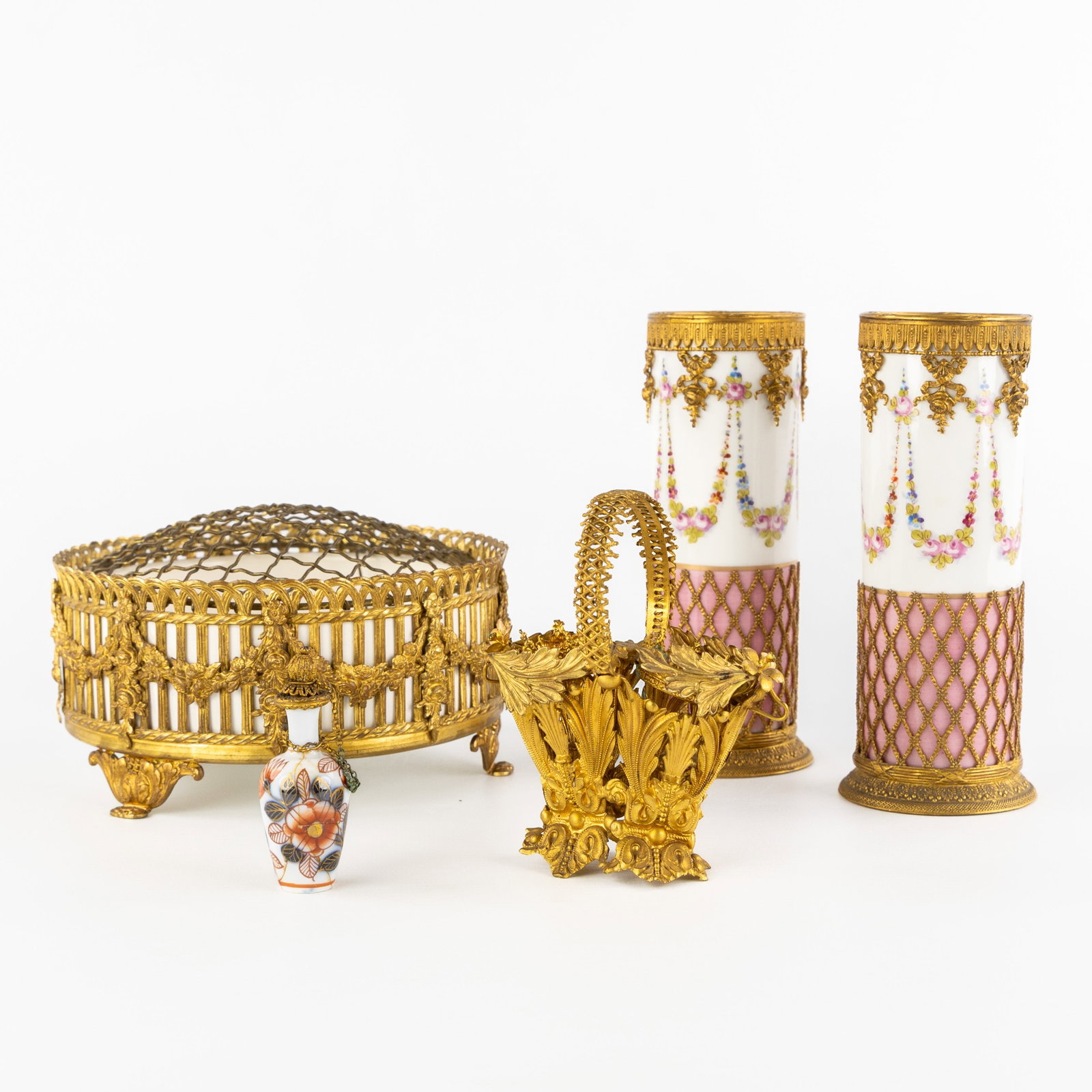 Sèvres and Waechtersbach, a pair of porcelain vases and a pique-fleur mounted with gilded: Sèvres and Waechtersbach, a pair of porcelain vases and a pique-fleur mounted with gilded brass, 19th century. Porcelain and gilded brass.A pair of cylindrical vases, hand-painted decoration with