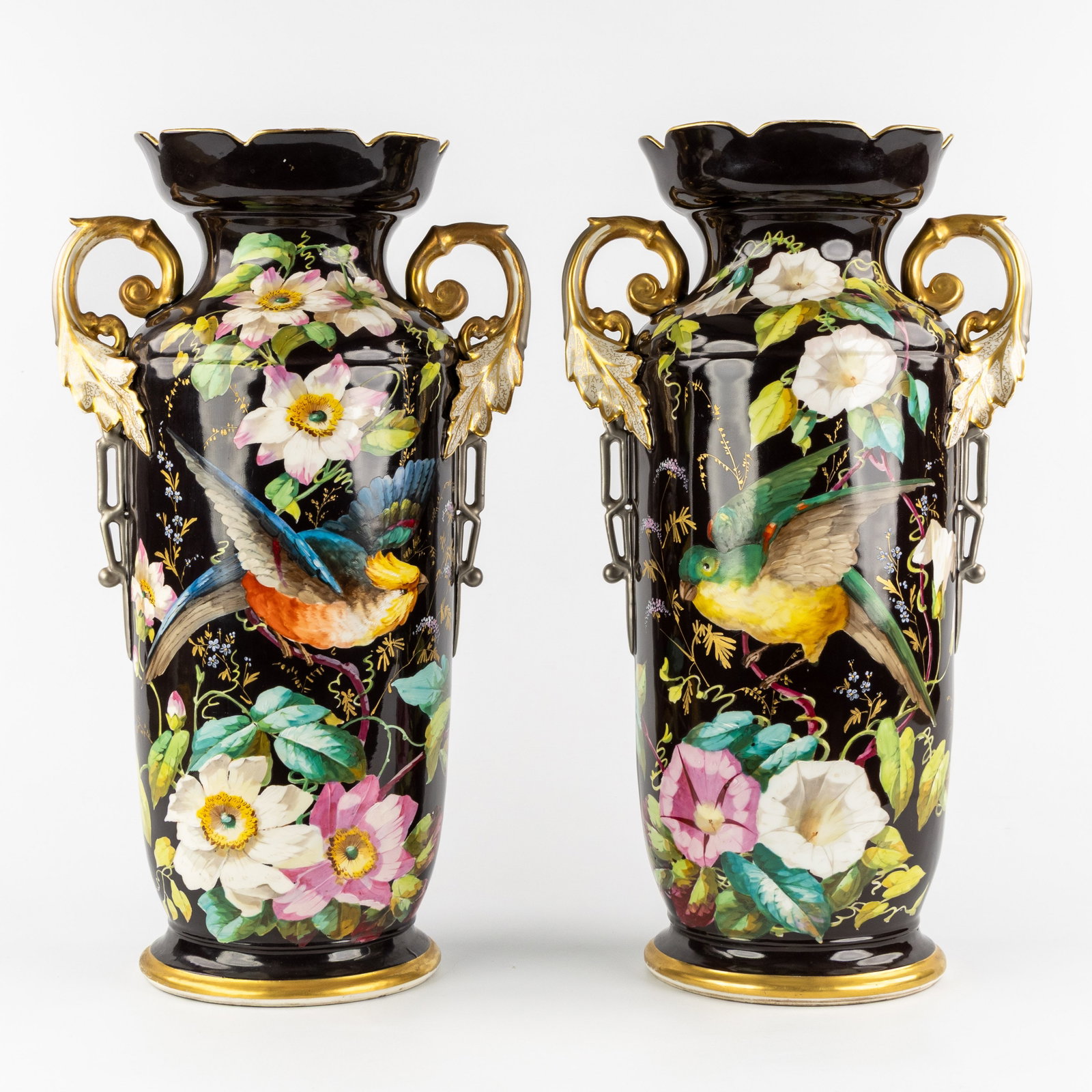 Vieux Paris, a pair of porcelain vases with hand-painted decors of flowers and parrots, circa: Vieux Paris, a pair of porcelain vases with hand-painted decors of flowers and parrots, circa 1900-1920. Polychrome and gilded porcelain, on a black ground.Hand-painted decorations with parrots and lu
