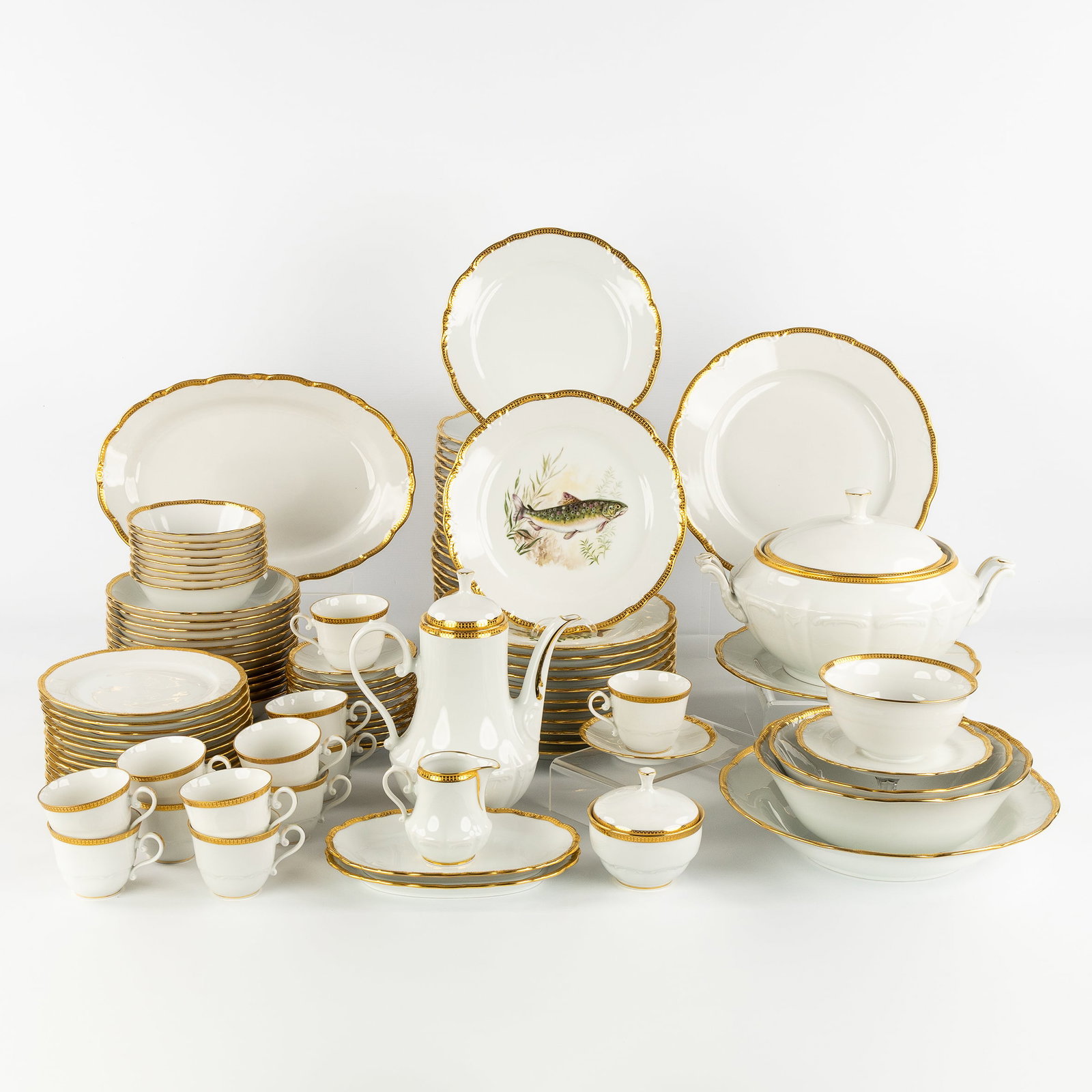 France Porcelaine, 'Deux Feux Or - Tirage Limité', a 105-piece porcelain dinner and coffee: France Porcelaine, 'Deux Feux Or - Tirage Limité', a 105-piece porcelain dinner and coffee service. Porcelain with gilded 'Deux Feux Or' decoration and fish.24 large plates (D: 24 cm).12 large