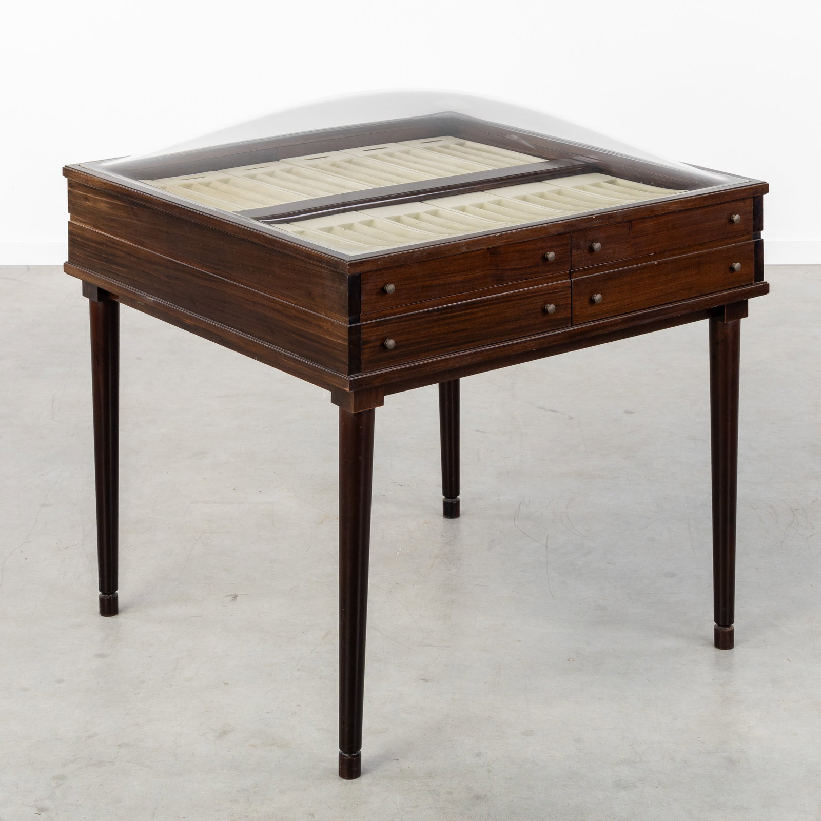 Christofle, a rosewood cutlery display table.: Christofle, a rosewood cutlery display table. Rosewood veneer and plexiglass.Display table with 8 drawers and a convex dome top.With display compartments for Perles, Chinon, Spatours, Cluny, America