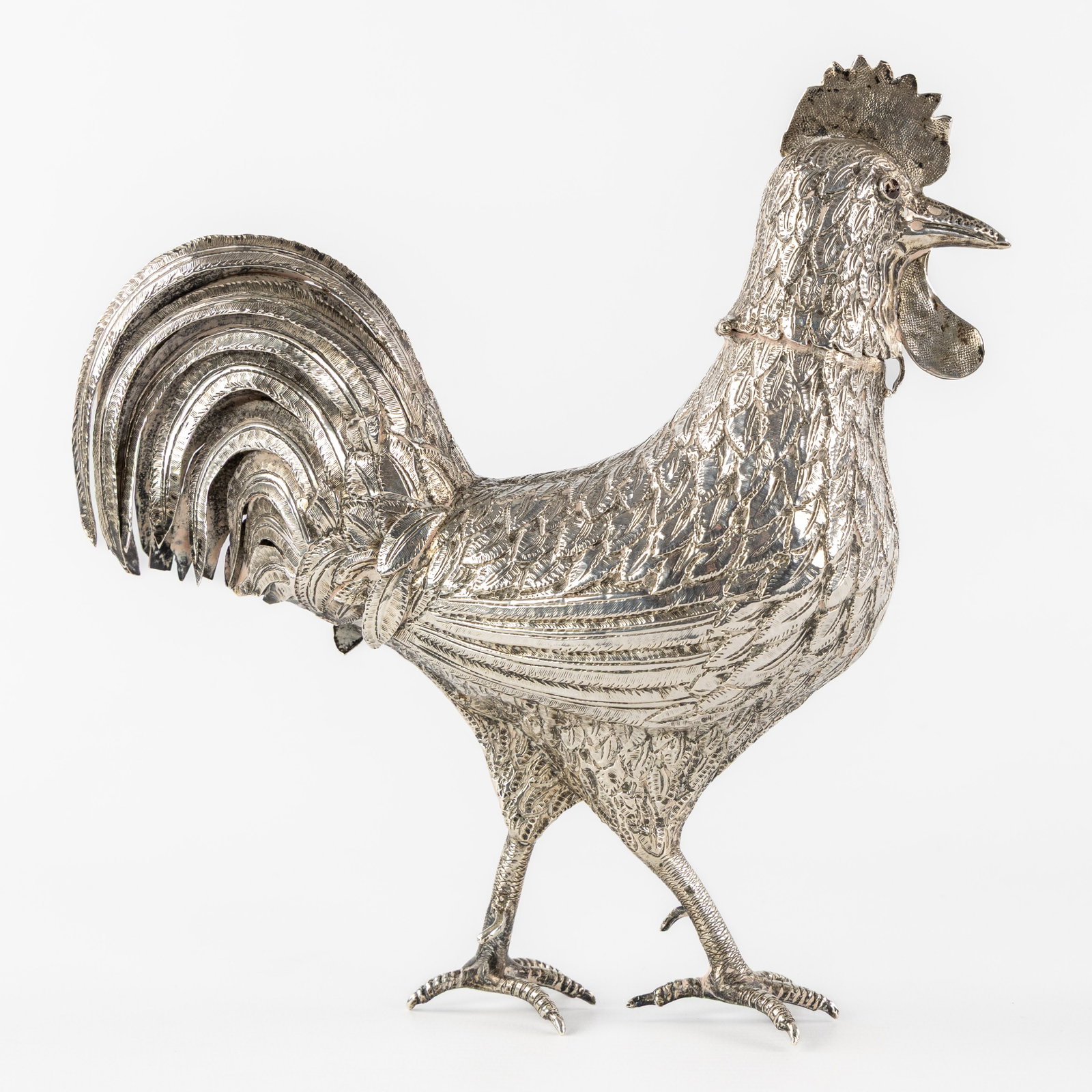 A Large silver rooster with openwork tail feathers, Netherlands, 1890. Silver, 405g.: A Large silver rooster with openwork tail feathers, Netherlands, 1890. Silver. A silver figurine in the shape of a rooster, with a hinged head (sand spreader?) and openwork tail feathers. Grade marked
