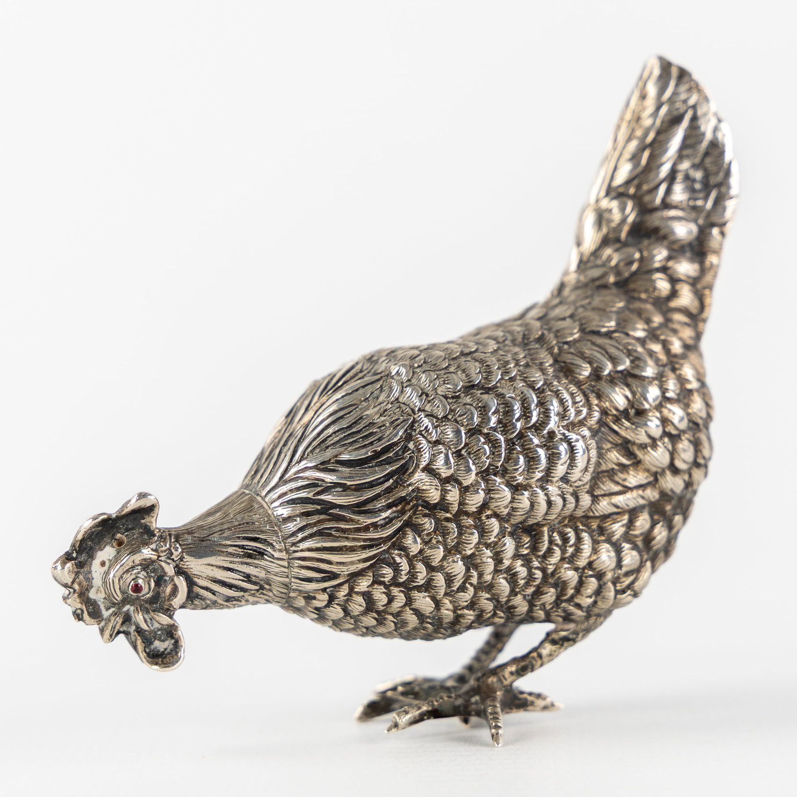 A Small Silver Chicken, Netherlands, 1814-1953. Silver, 44g.: A Small Silver Chicken, Netherlands, 1814-1953. Silver. A silver pecking rooster.Grade mark with a lion walking to the right, for 833/1000, Netherlands, period 1814-1953.Maker's mark (?): 'N2' in a