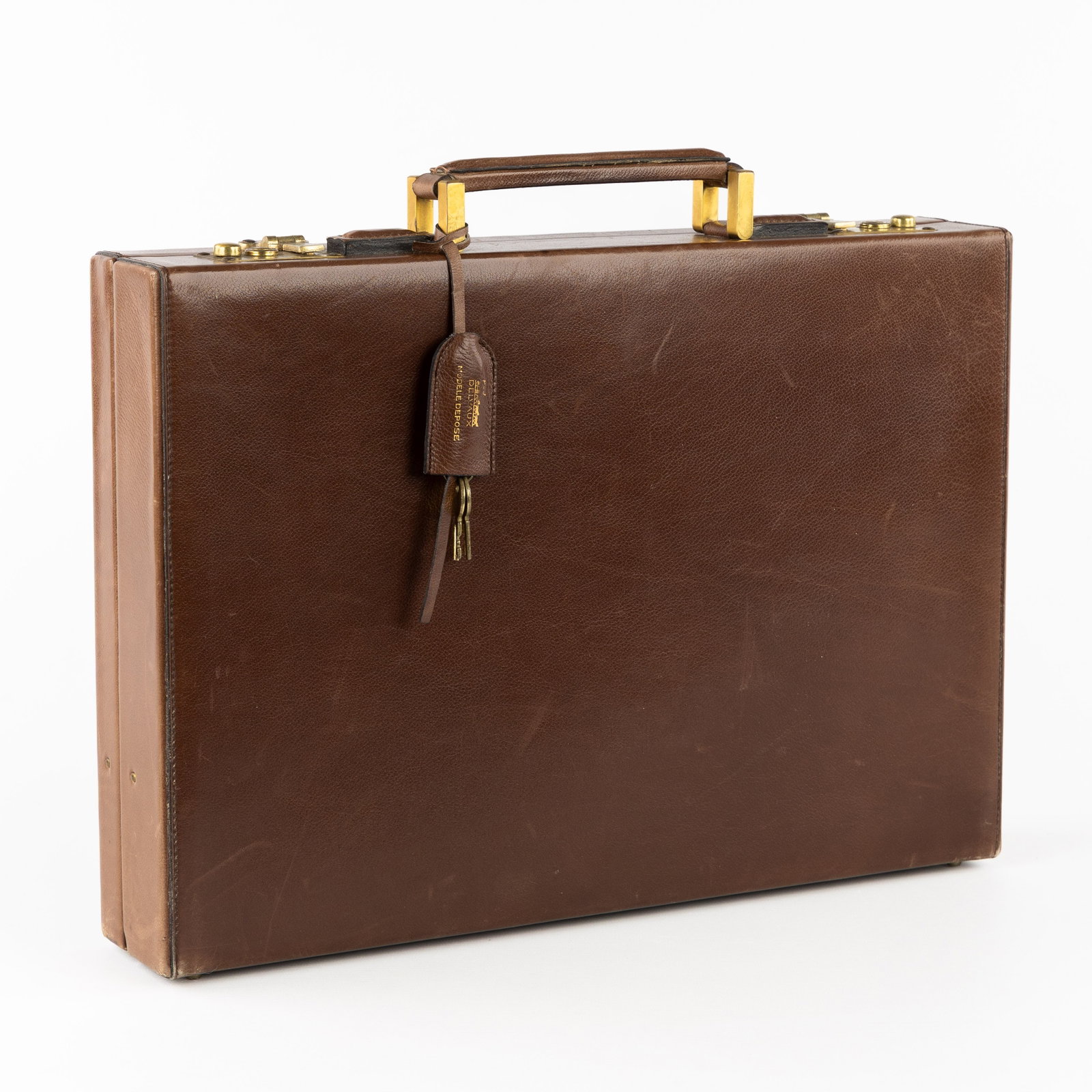 Delvaux, a briefcase or attaché case, brown leather.: Delvaux, a briefcase or attaché case, brown leather. Chestnut brown leather and gold-plated hardware.Marked and labeled 'Delveaux - Modele Déposée'.Including the keys. (43.5