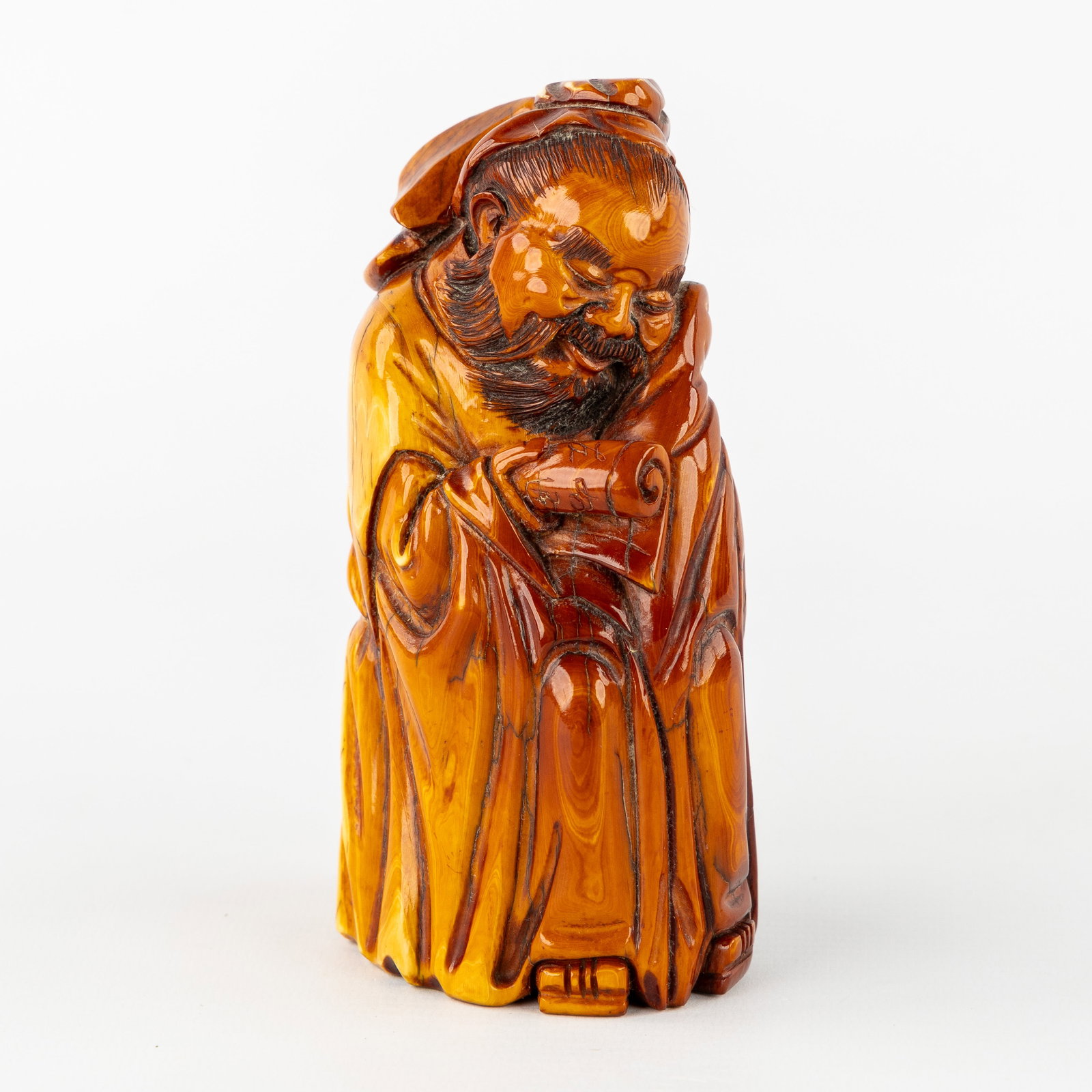 A Chinese sculpture of an Immortal or Scholar, sculptured mammoth ivory.: A Chinese sculpture of an Immortal or Scholar, sculptured mammoth ivory. Sculptured mammoth ivory. Depiction of an imortal, wise man or scholar, with a scroll. Marked at the bottom with a maker's mark