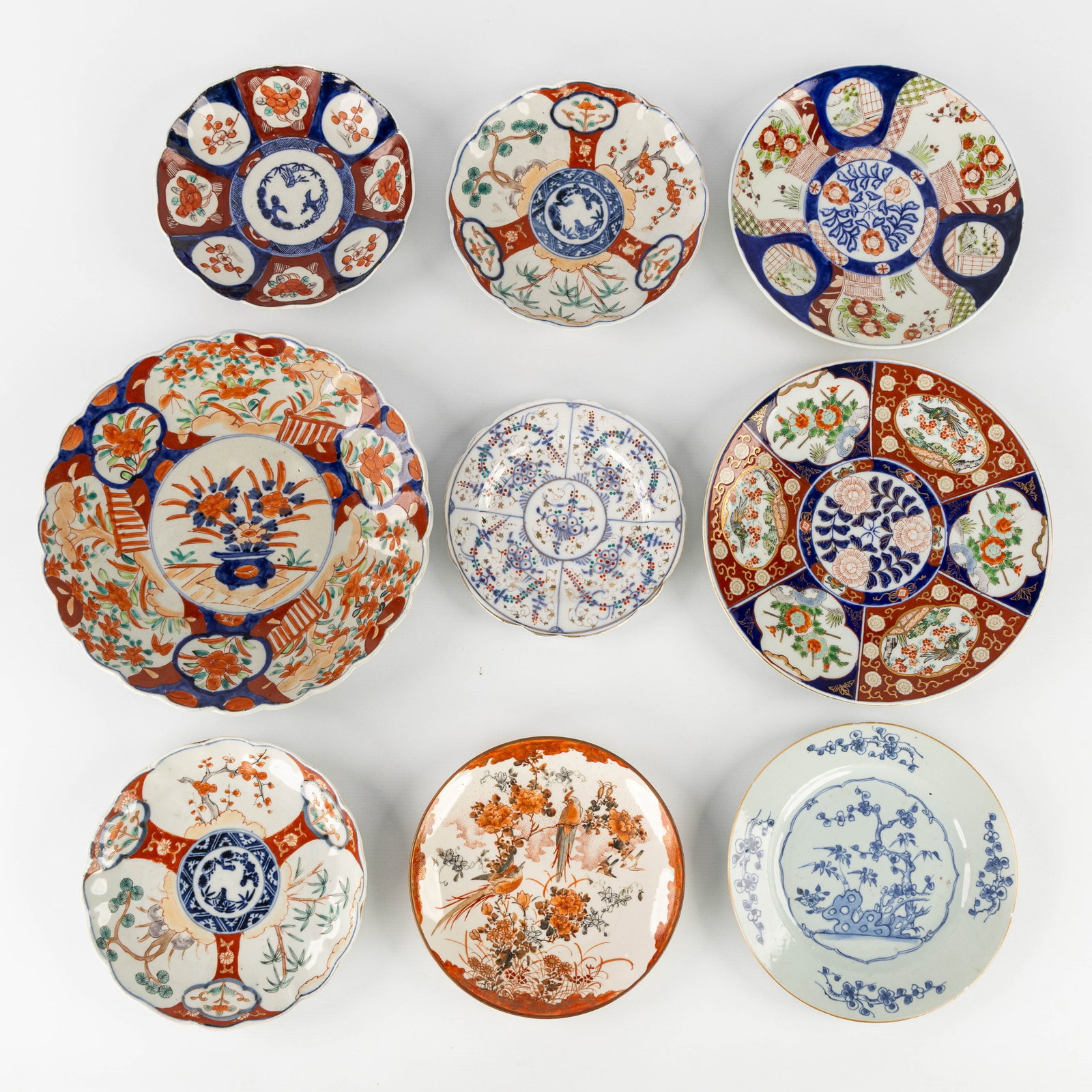 Nine Japanese porcelain plates, Blue and White, Kutani and Imari, 19th and 20th C.: Nine Japanese porcelain plates, Blue and White, Kutani and Imari, 19th and 20th century. Blue and White.Plate, decorated with blossom branches, bamboo, and rock (Chinese style) (D: 23 cm).
