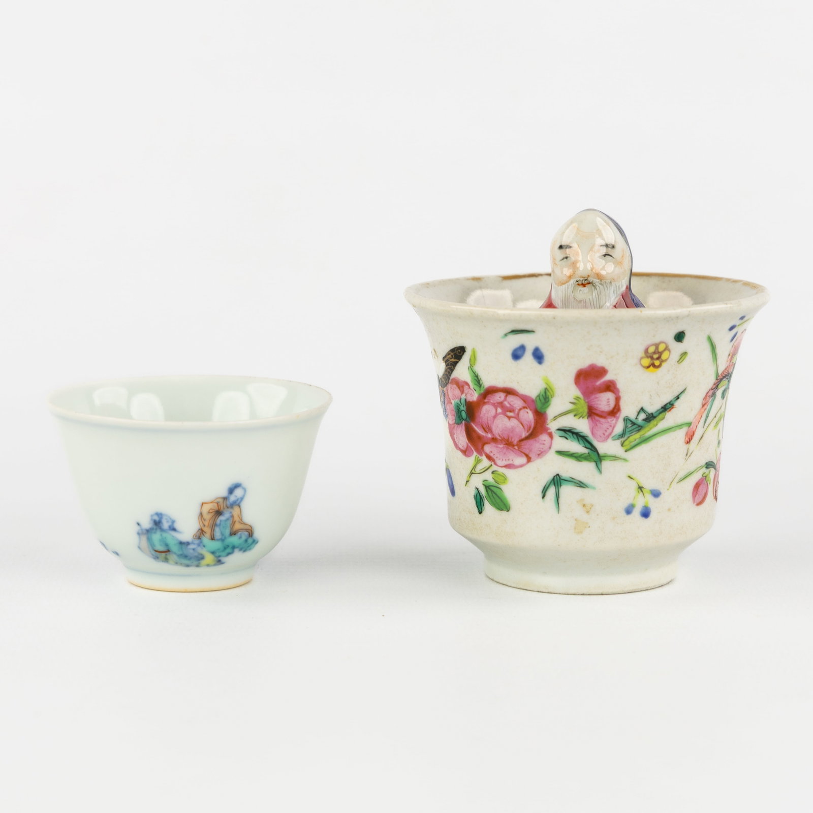 A Chinese Famille Rose 'Surprise Cup' and a Doucai wine cup, 19th/20th C.: A Chinese Famille Rose 'Surprise Cup' and a Doucai wine cup, 19th/20th century. Chinese porcelain. Surprise cup or amusement cup, famille rose, decorated with butterflies, peonies, peaches and bl