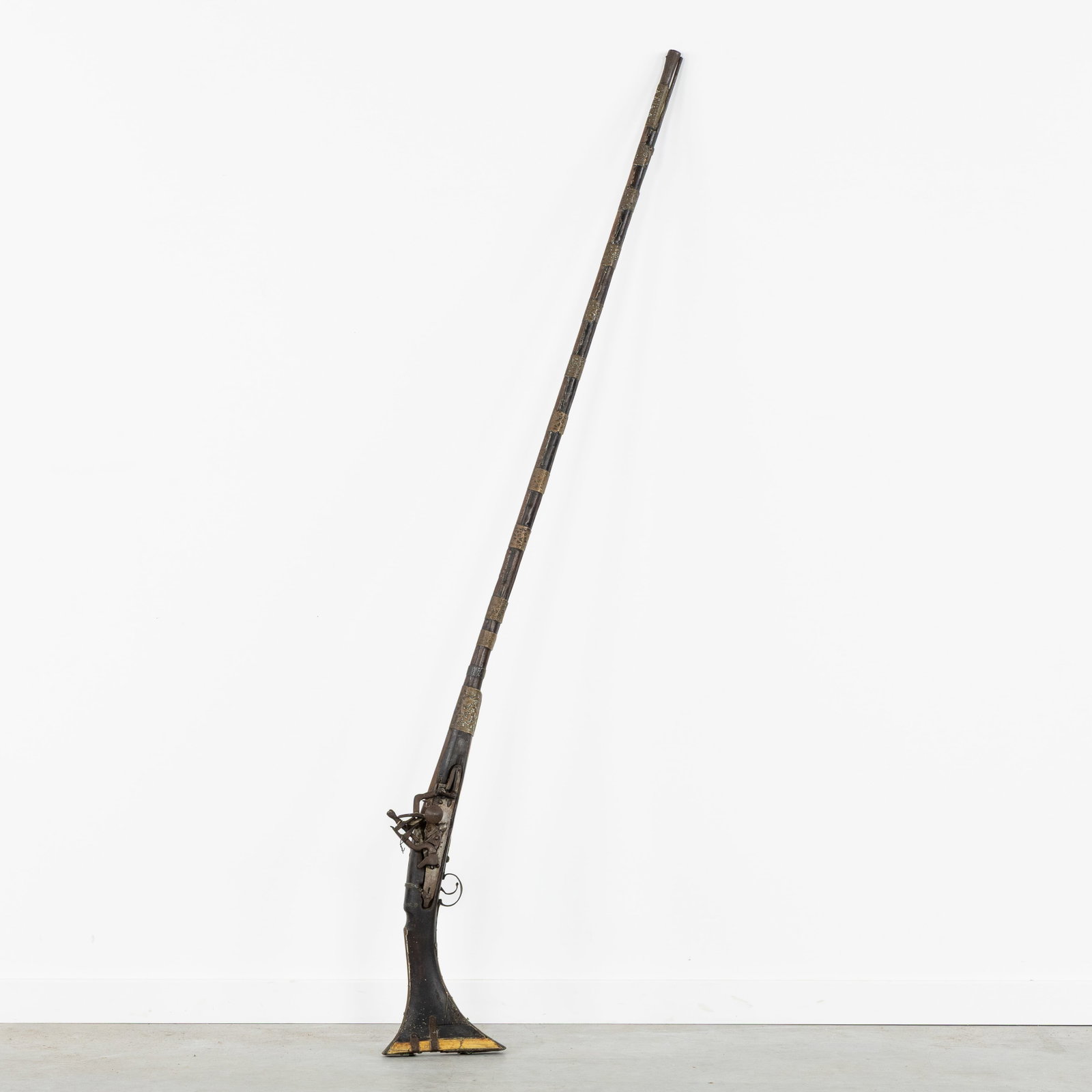 An Antique Moukahla or Kabyle flintlock musket, North Africa, 19th C.: An Antique Moukahla or Kabyle flintlock musket, North Africa, 19th century. Wood, metal, and copper.Musket rifle with flintlock of miquelet lock.Decorated with bone and copper repoussé bands.</