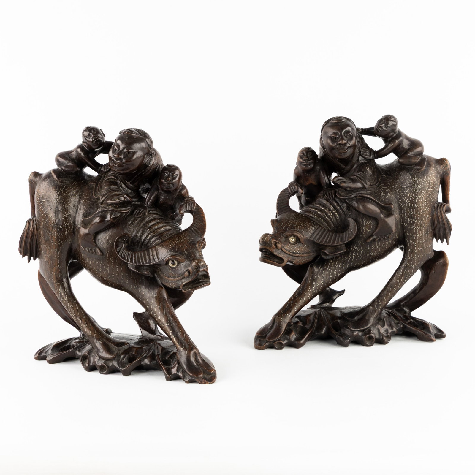 A Pair of Chinese statues, 'Laozi Leaves Civilization', sculptured wood and silver inlay.: A Pair of Chinese statues, 'Laozi Leaves Civilization', sculptured wood and silver inlay. Wood, inlaid with silver and richly decorated.Classic depiction of the legendary philosopher Laozi on his jour