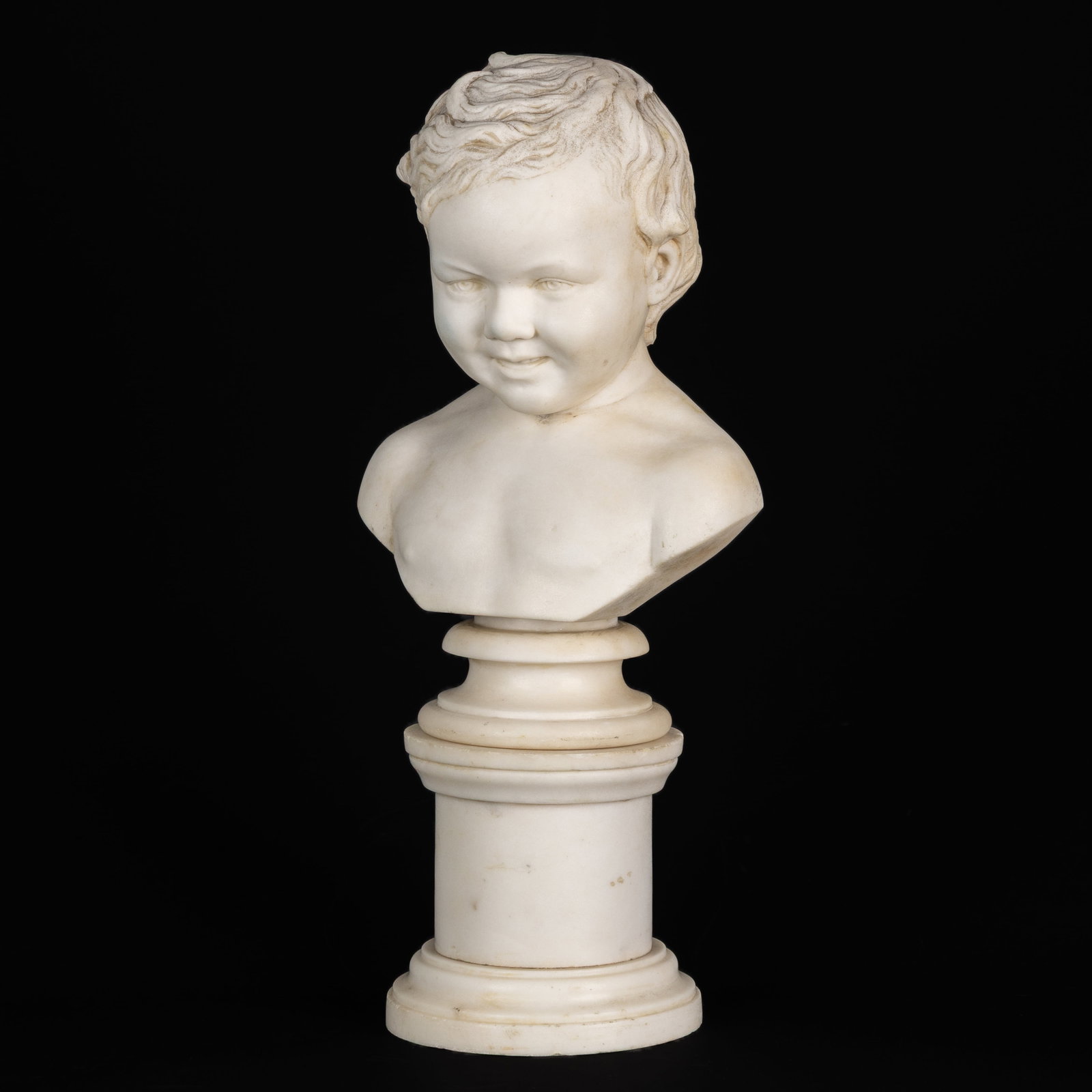 'Bust of a Boy', a Carrara marble sculpture on a pedestal, 19th/20th C.: 'Bust of a Boy', a Carrara marble sculpture on a pedestal, 19th/20th century. Sculptured Carrara marble.Bust standing on a pedestal.Unsigned. Total height: 43.5 cm.