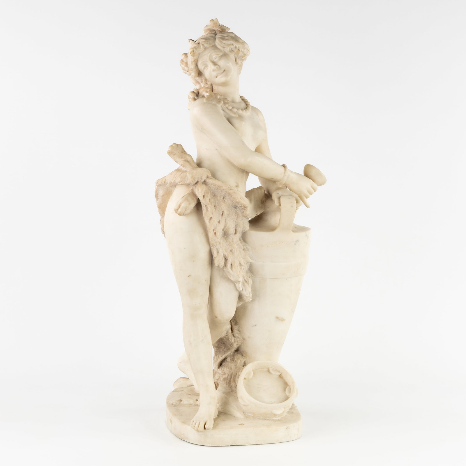 A Sculptured Carrara marble statue of a 'Bacchante', signed Chevalier, 19th C.: A Sculptured Carrara marble statue of a 'Bacchante', signed Chevalier, 19th century. Sculptured Carrara marble.Depiction of a Bacchante, with lion skin, tambourine, wine jug, and vine wreath.Signed