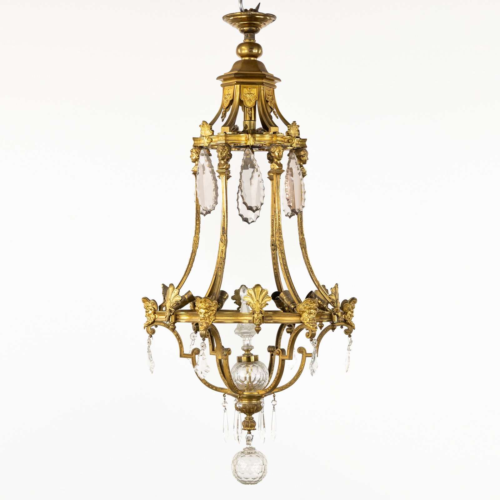 A Large French castle chandelier with grotesques, gilded bronze and crystal, Louis XVI style.: A Large French castle chandelier with grotesques, gilded bronze and crystal, Louis XVI style. Gilded bronze and cut crystal.Seven light points.Decorated with grotesques and female heads (espagnolett