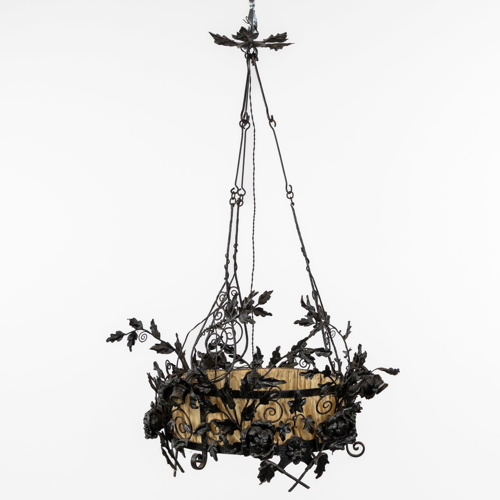 A Wrought iron chandelier, in the style of Louis Van Boeckel.: A Wrought iron chandelier, in the style of Louis Van Boeckel. Wrought iron and fabric.Decorated with flowers and leaves.In the style of Louis Van Boeckel (1857-1944).3 light points.