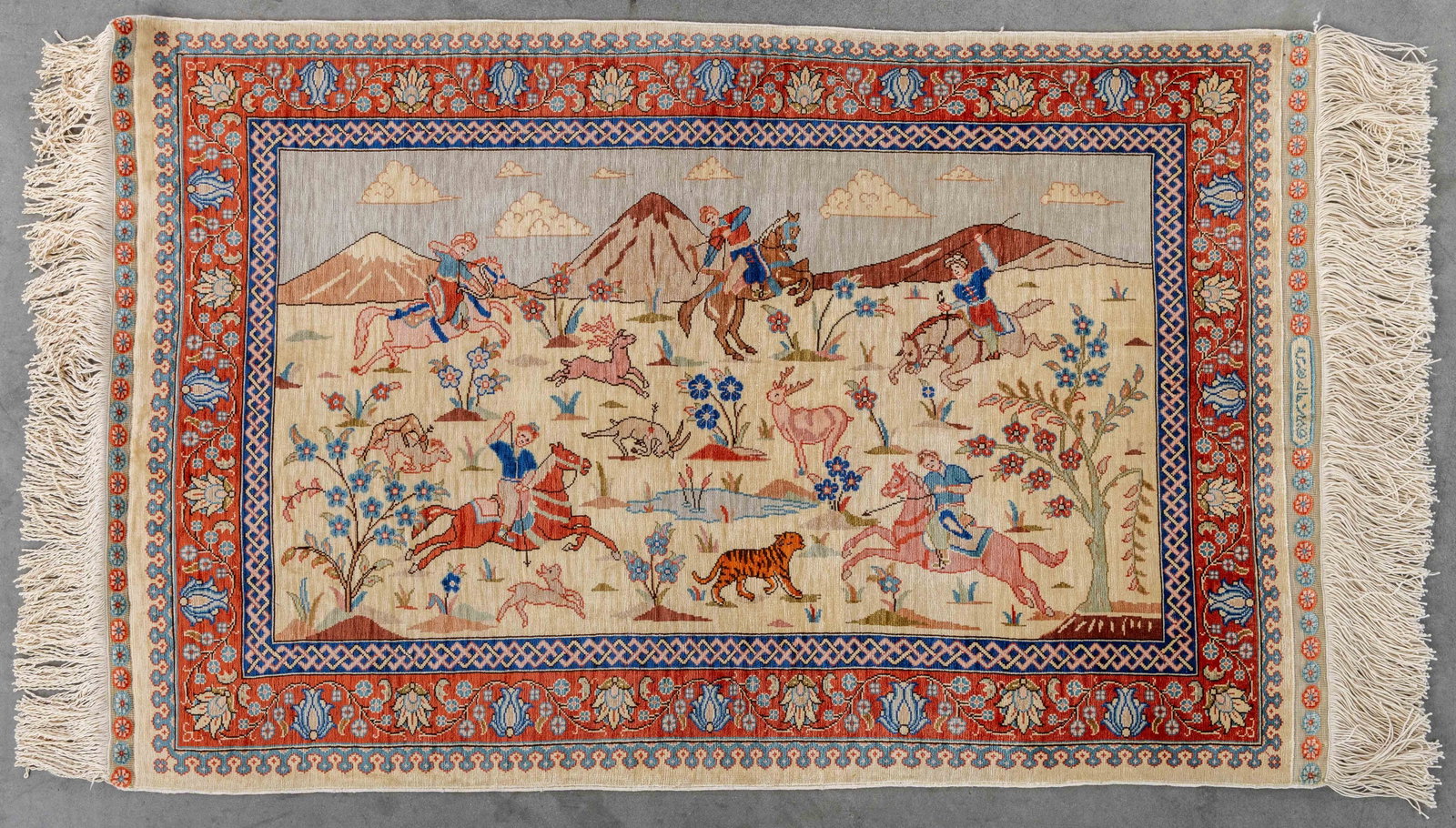 An Oriental hand-made carpet, Hereke, hunting scene, silk. Signed (84 x 54 cm).: An Oriental hand-made carpet, Hereke, hunting scene, silk. Signed (84 x 54 cm). (84 x 0 x 54 cm)
