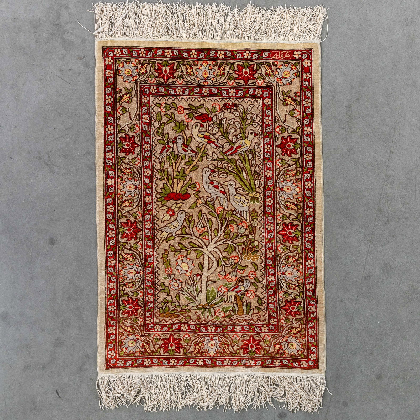 An Oriental hand-made carpet, Hereke, silk, signed (52 x 76 cm). (1 of 7)