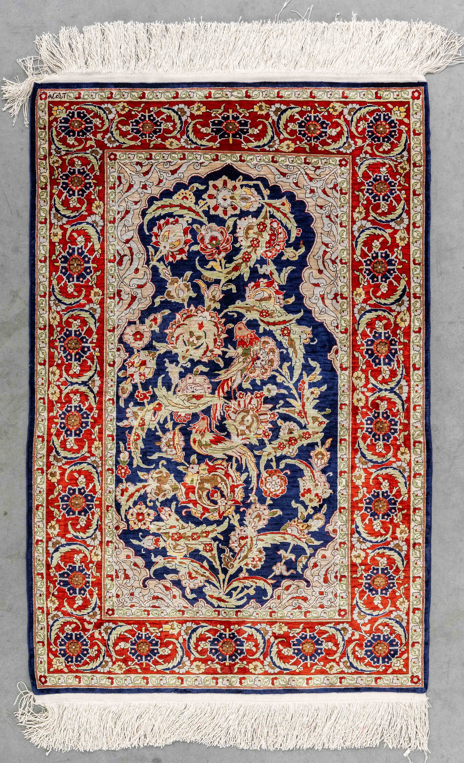 An Oriental hand-made carpet, Hereke, silk, signed (77 x 116 cm). (1 of 8)