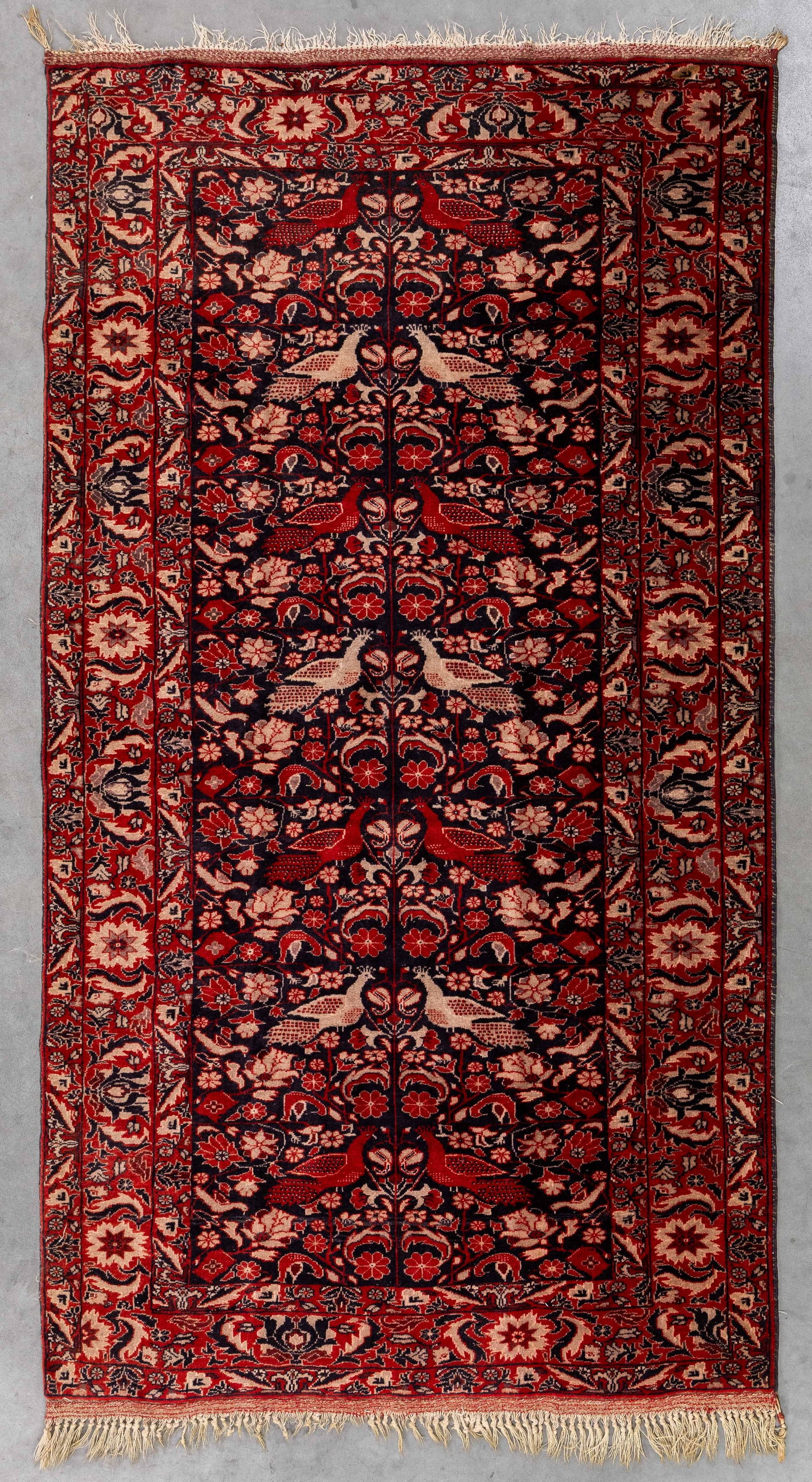An Oriental hand-made carpet with peacock decoration, Persia (195 x 107 cm). (1 of 7)
