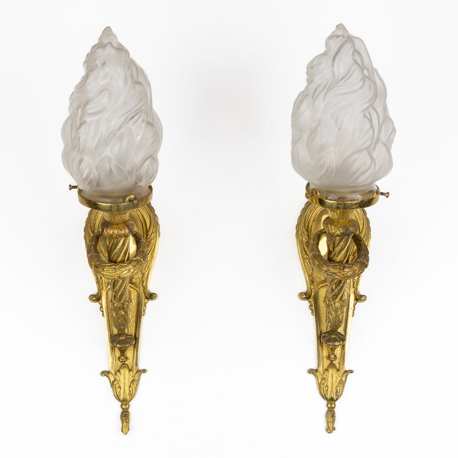 A Pair of flambeau lamps or torch-shaped wall scones, Louis XVI style, gilded bronze and frosted: A Pair of flambeau lamps or torch-shaped wall scones, Louis XVI style, gilded bronze and frosted glass, 20th century. Gilded bronze and frosted glass.A pair of torch-shaped wall lamps, appliques, or f
