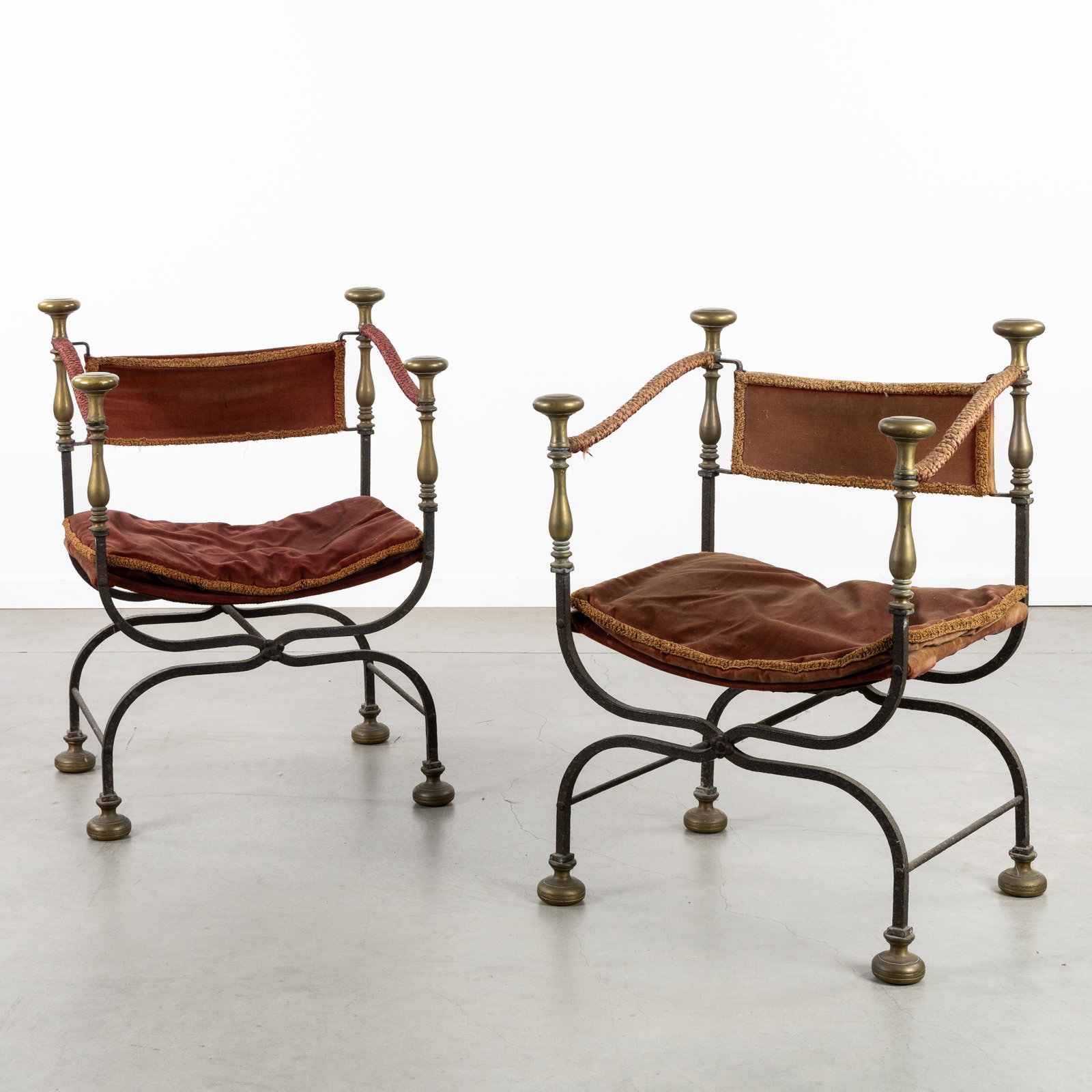 A Pair of Curule armchairs, cast iron and bronze, circa 1900-1920.: A Pair of Curule armchairs, cast iron and bronze, circa 1900-1920. Cast iron frame, finished with bronze ball feet and knobs/finials.Curule or Savonarola armchairs, with red velvet upholstery.Inspir