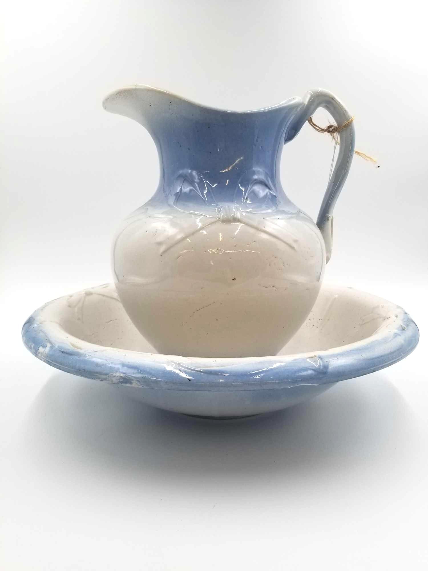1800's Large Blue and White Wash Basin & Pitcher: Intact and original wash set. Includes a sky blue and light white porcelain pitcher and matching basin. Line with a simple ribbon decoration. Minor crazing and chips due to age and use. Great centerpi