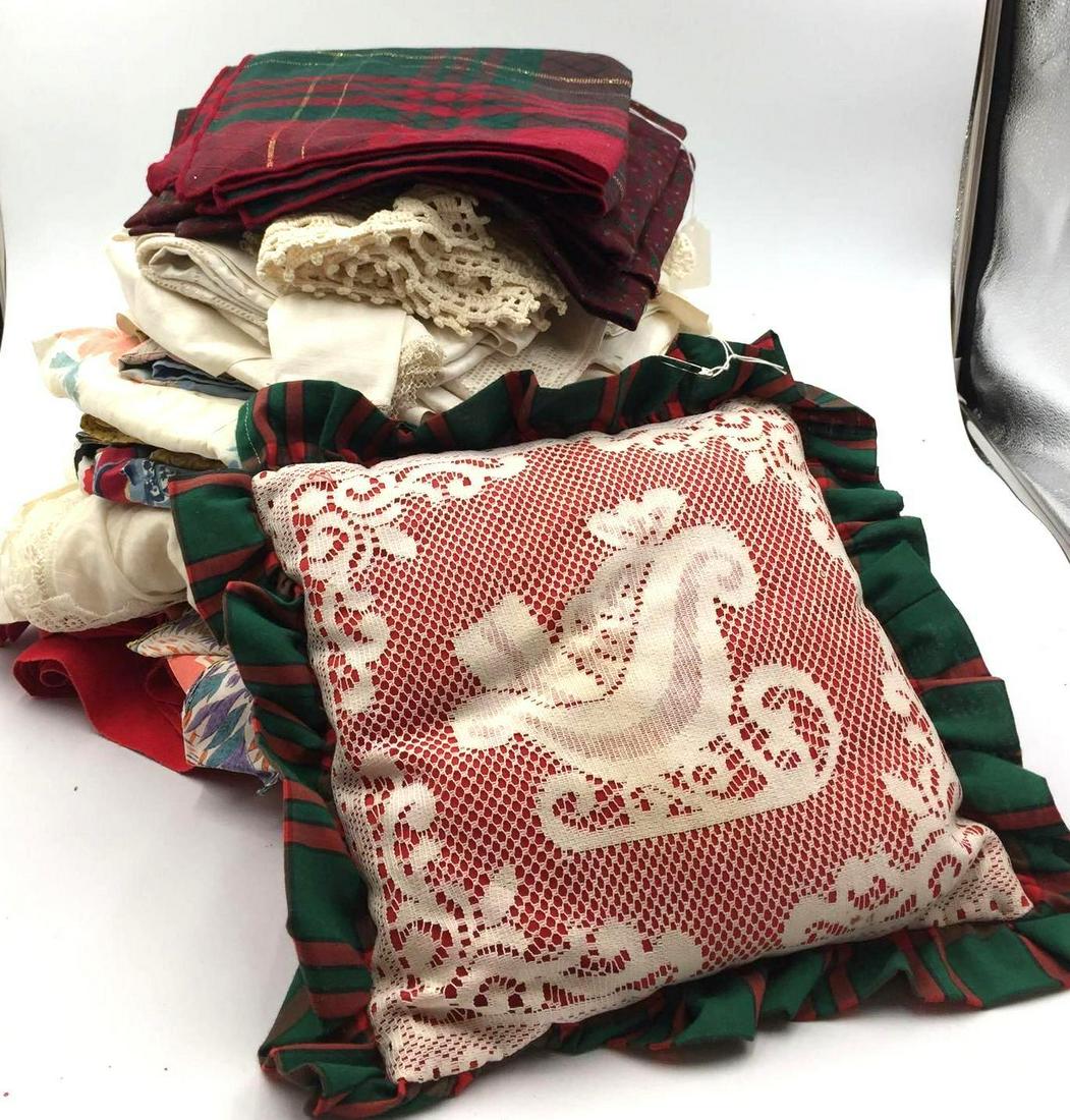 Vintage Linens Box Lot: This box lot contains various linen, doilies, aprons, and a Christmas pillow. Many of the pieces are Christmas style decor and patterns, others are not.