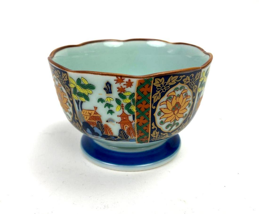 Japanese Porcelain Amari Arita Bowl: Japanese porcelain, footed bowl with Amari Arita marking. Temple and floral design. Scalloped rim. Pale mint interior. 4in diameter; 2.25in deep.