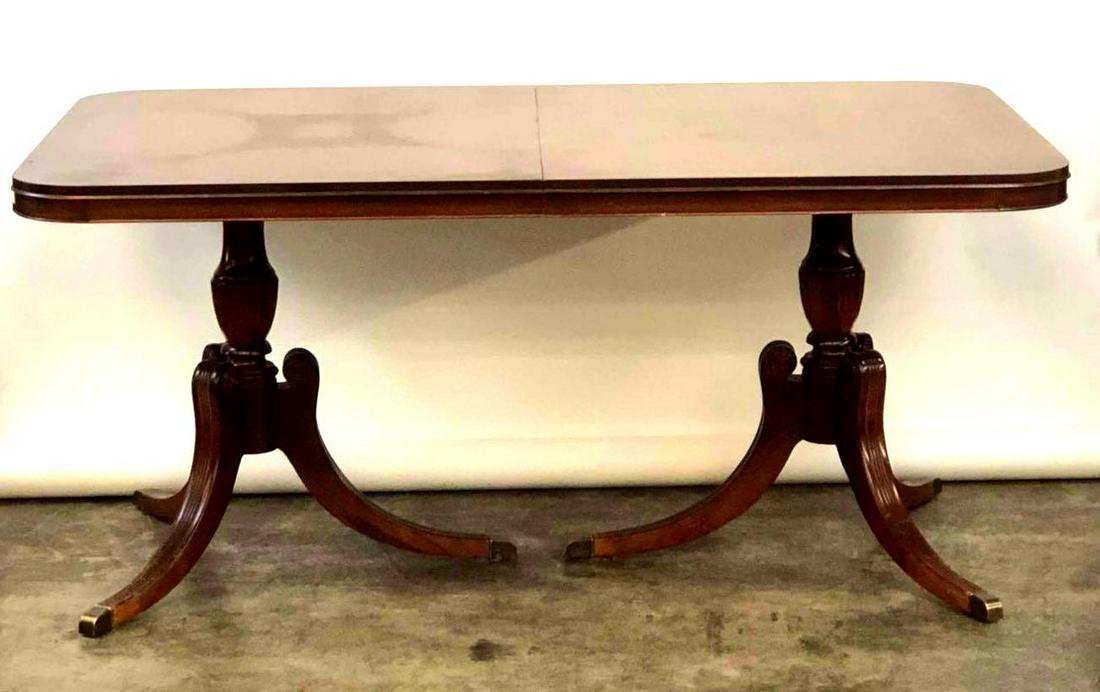 Duncan Phyfe Dining Table: Duncan Phyfe dining table with pedestal legs and brass feet. Table measures 66 inches long, 42 inches wide, and 30.5 inches tall.