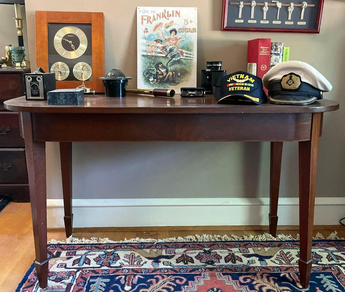 Wall Table with Assorted Decor: This lot includes a table that measures 51 inches long, 23 inches wide, and 29.5 inches tall,?as well as a vintage Kodak Brownie camera, naval hats, compasses, spyglass and binoculars, Airguide clock/