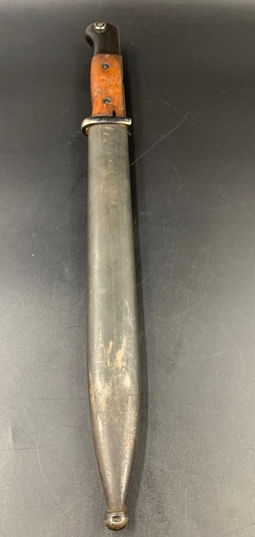 WWII German Bayonet 44ASW 3382EE S/245 554: WWII German bayonet with a wooden handle in a metal scabbard. The scabbard is stamped 44asw and 3382 ee. The bayonet is stamped S/245 and 554 on the upper portion of the blade. On the pommel of the ha