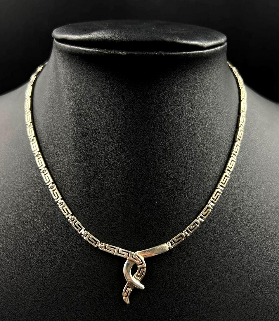 Sterling Silver Greek Key Chain Necklace: Sterling silver Greek Key chain necklace and a central swoop pendant. The 925 marking can be found on necklace clasp. Necklace chain is 17 inches long and weighs a total of 0.48ozt.