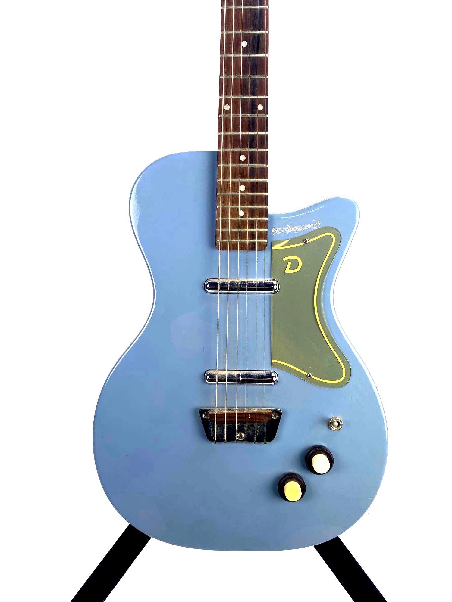 1956 Danelectro TU Reissue Electric Baby Blue Guitar with Soft Case: Danelectro electric guitar 1956 TU reissue model, features a powder blue finish. Guitar features vintage bridge with wooden rest, lipstick style single coil pickups, and a rosewood fret board. This gu
