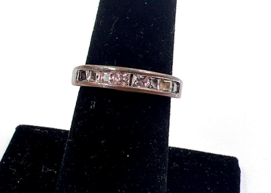 Sterling Silver Wedding Band: Sterling silver wedding band with princess cut stones, possibly tourmaline, in a channel setting. The ring is a size 6.5, is stamped 925 H on the interior of the shank, and weighs 0.09 ozt Metal Type: