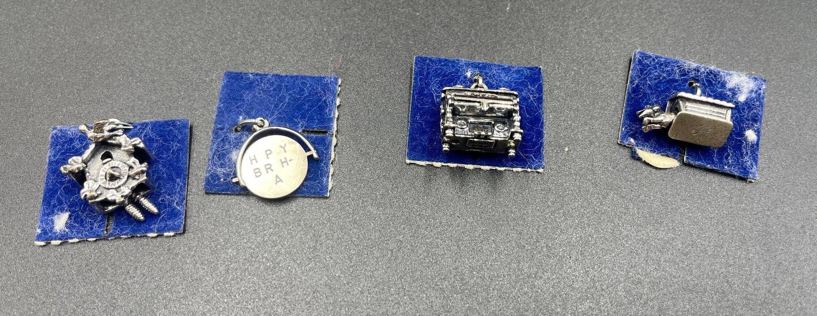 Sterling Silver Charm Collection: Collection of four sterling silver charms for charm bracelets. Designs included in this lot are a cuckoo clock, a spinning happy birthday medallion, a piano, and a dog house with dog. "Beau Sterli