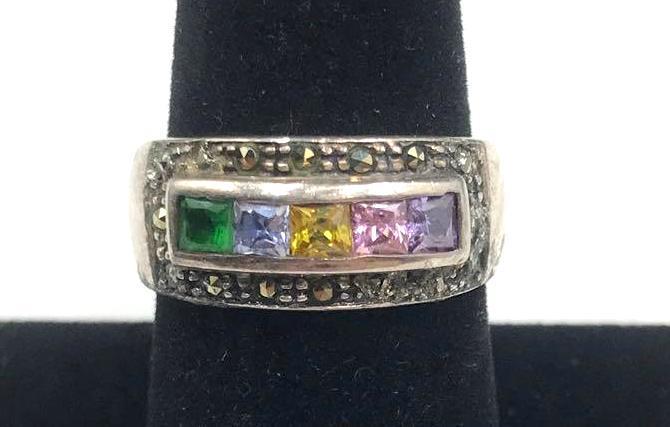 Sterling Silver and Mulit-color Glass Gem Ring: Sterling silver ring, featuring five glass gems of varying colors. Colors represented are green, yellow, blue, pink, and purple. 925 marking can be found in the ring band interior. Ring is a size 7.5