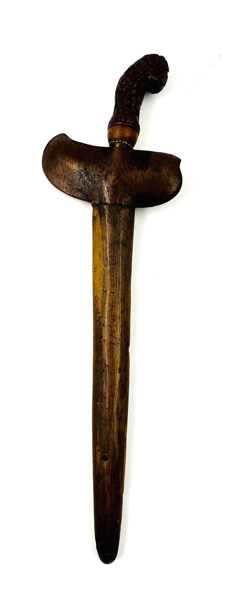 Keris Dagger and Scabbard: Keris Dagger and Scabbard. The dagger features a 3.5-inch hand-carved ornate floral handle with an ornate brass pommel. The 9.75-inch curved blade does have some rust. The wooden scabbard is hand-carv